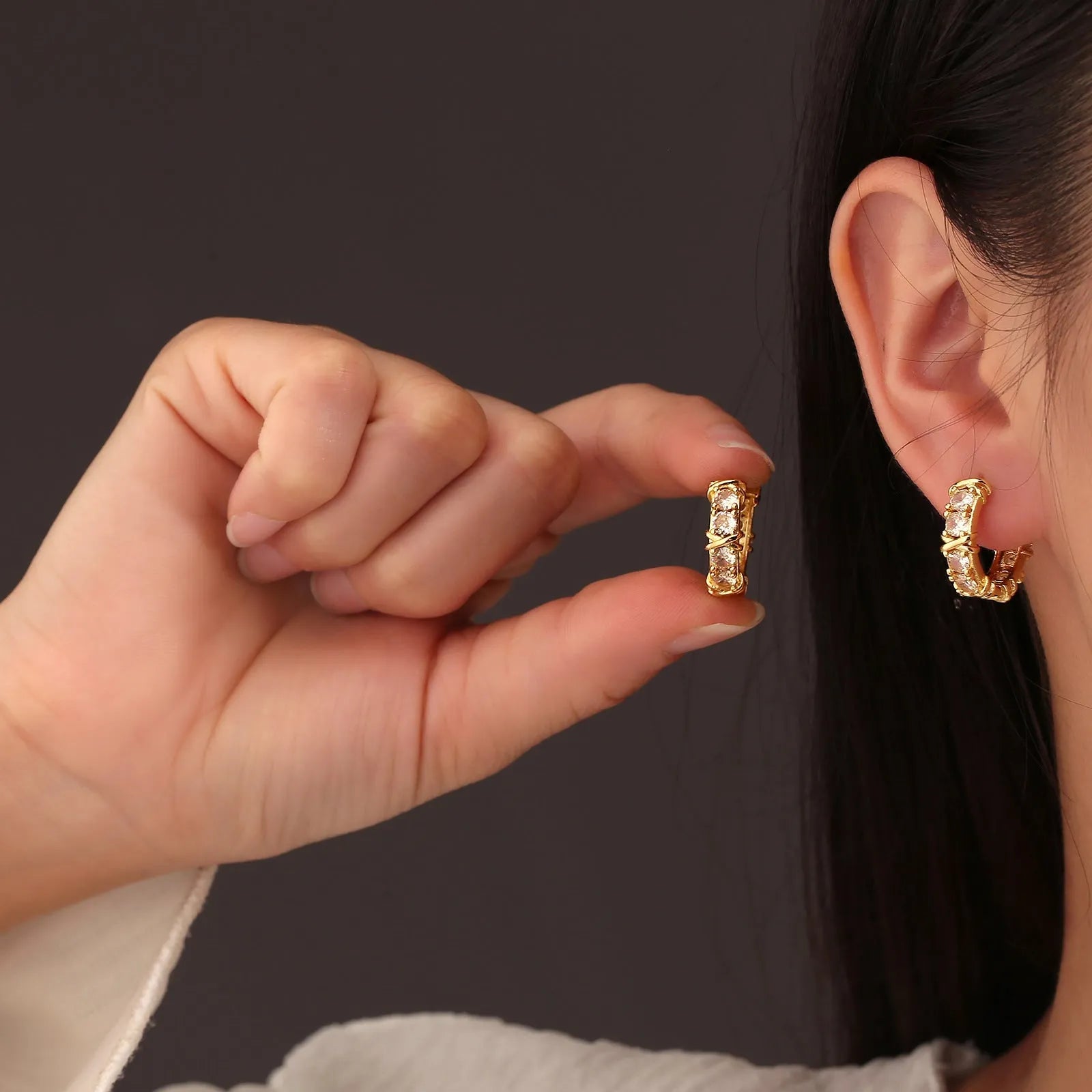 A pair of geometric hexagonal clover cross earrings with an elliptical shape in a gold or silver electroplated finish.