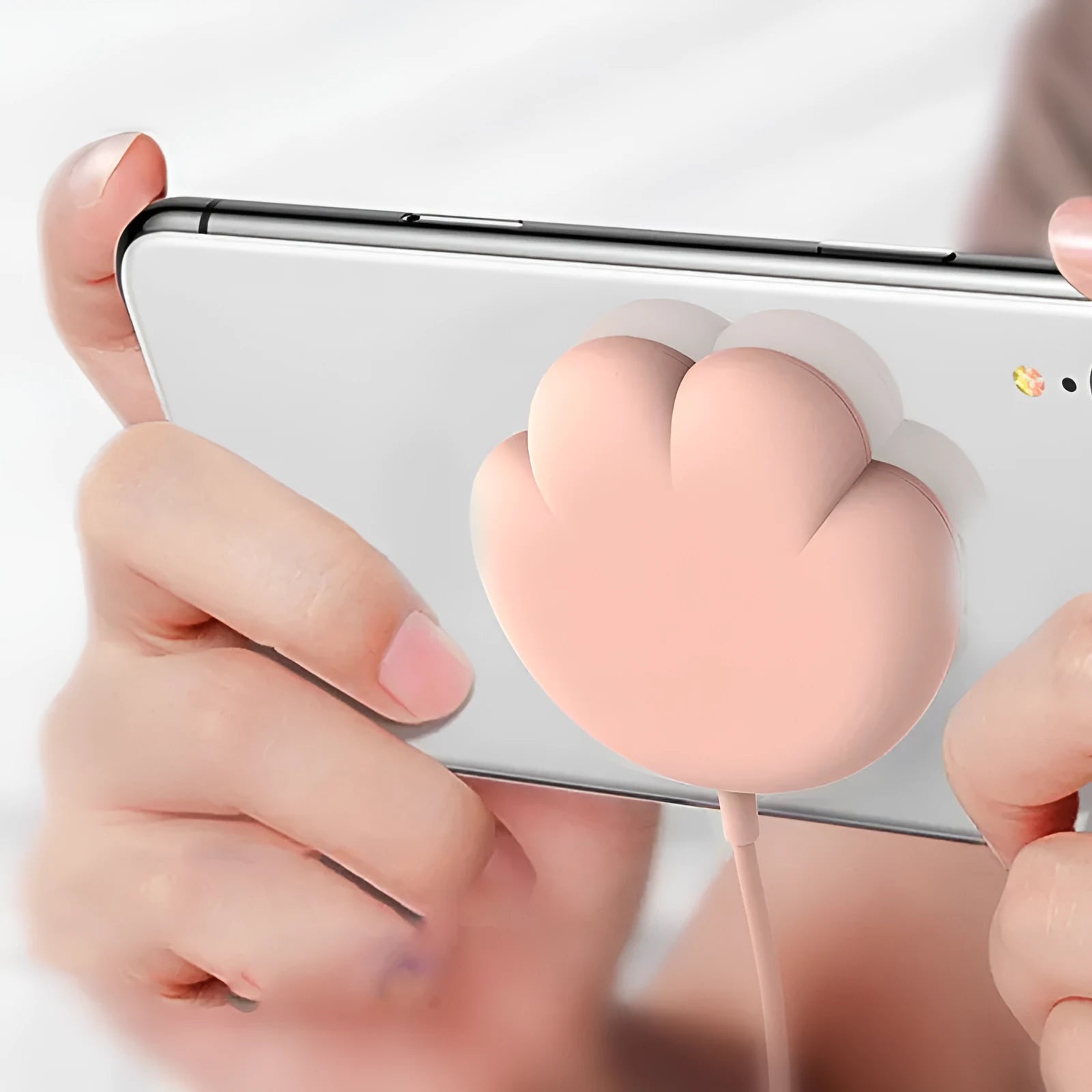 Pink cat claw sucker wireless charger with USB cable on a desk