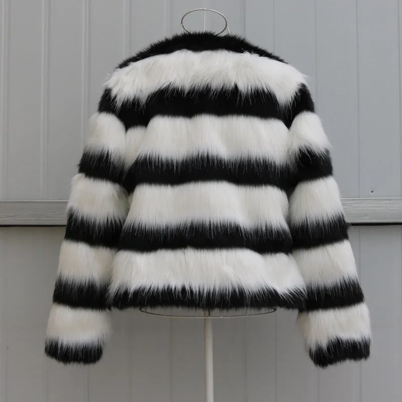 Women's long-sleeved black and white striped faux fur leather jacket on a hanger.