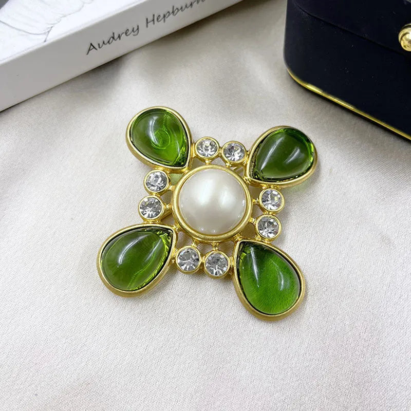 Close-up of vintage medieval baroque cross brooch with crystal accents on zinc alloy.