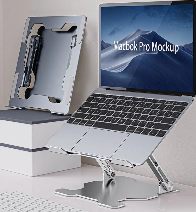 Grey aluminium folding laptop stand shown at an adjustable angle on a wooden desk.