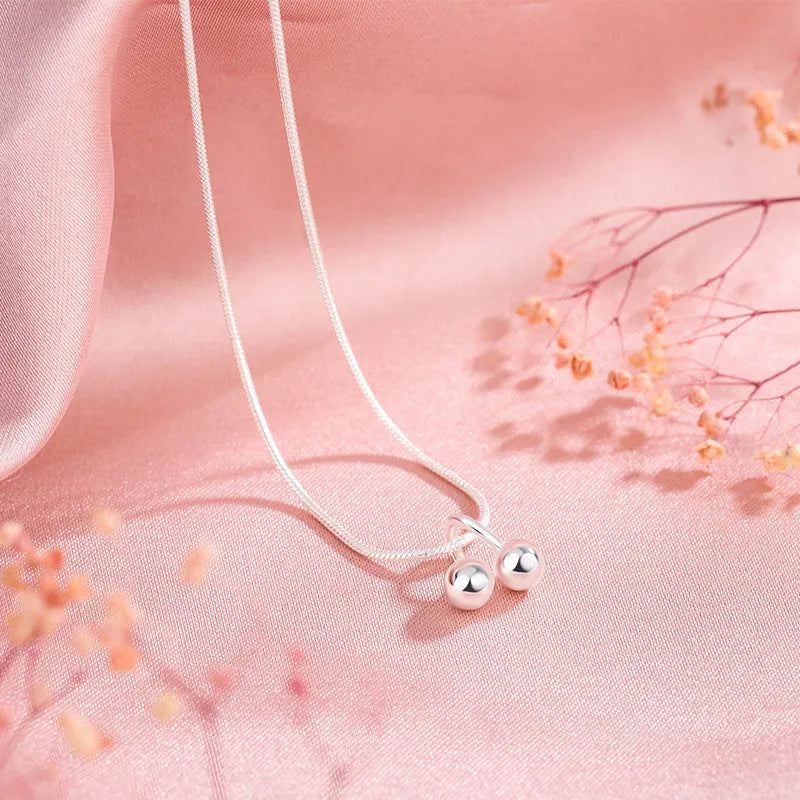 Silver cherry pendant necklace on a snake bones chain, adjustable from 21cm to 50cm length.