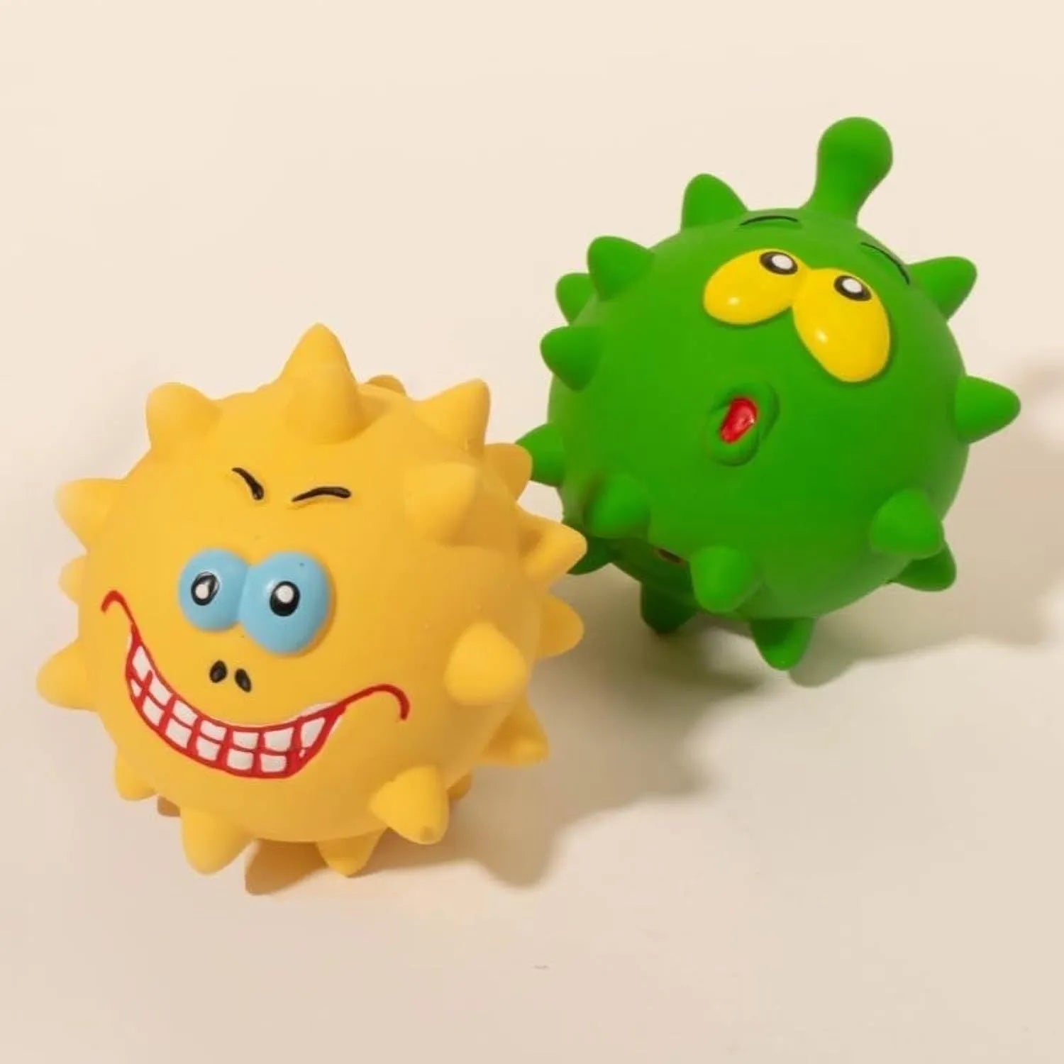 Set of four colourful squeaky dog balls with cute faces, made from natural latex rubber.