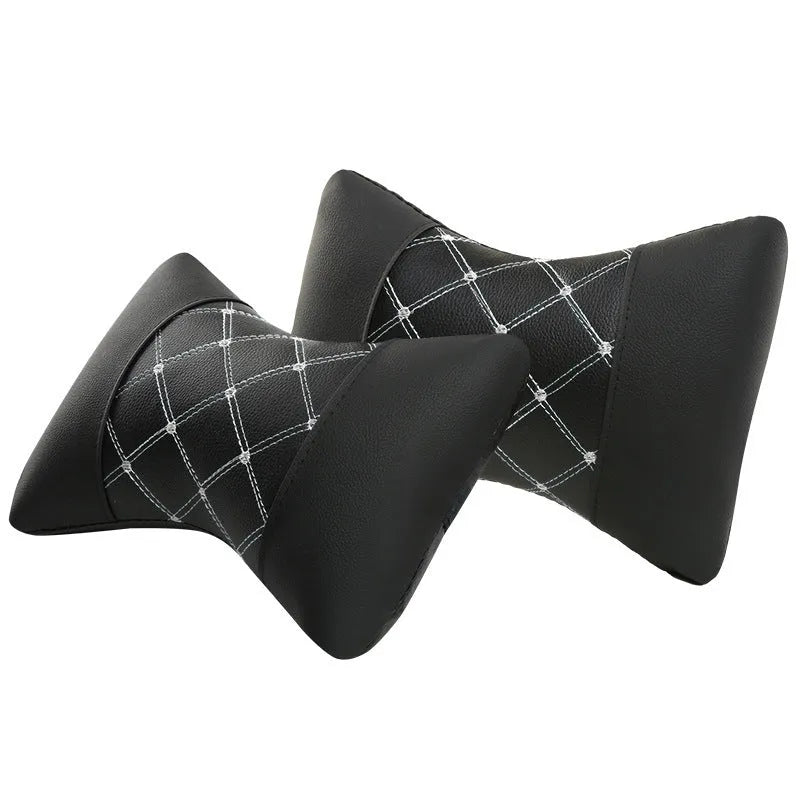 Black quilted leather car headrest pillow with contrast stitching, shown on a car seat.
