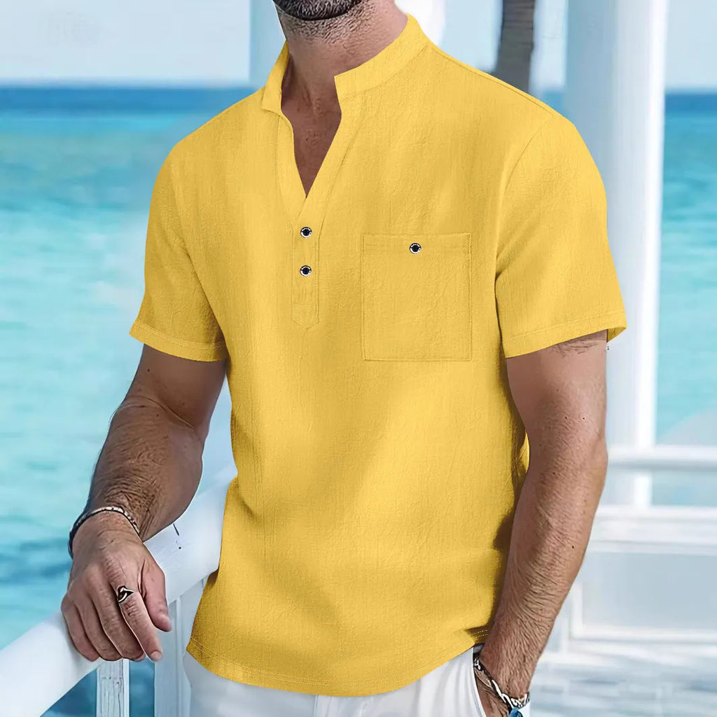 Man wearing a light blue stand collar linen blend t-shirt with short sleeves and a loose fit.