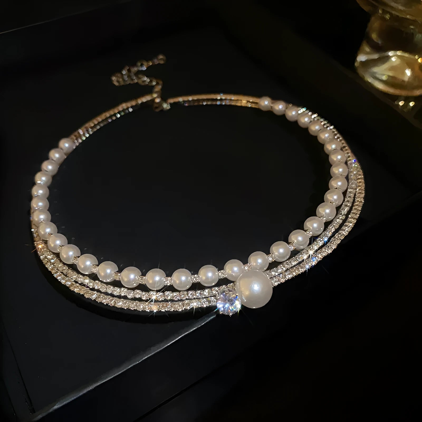Silver curved geometric necklace resting on a collarbone, showing its alloy construction and electroplated finish.