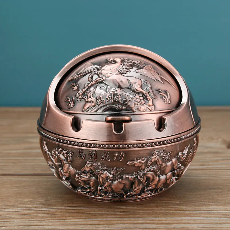Bronze and red copper alloy decorative ashtray with smoke-extinguishing slot on a table.