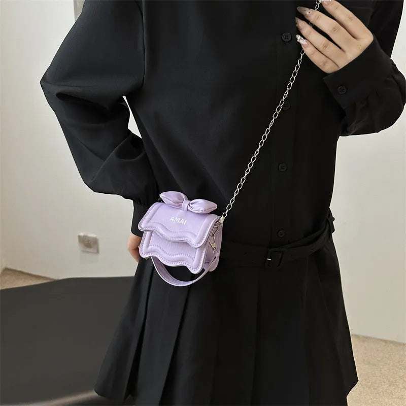 A women's mini crossbody bag in PU leather with an adjustable strap, shown in multiple colour options.