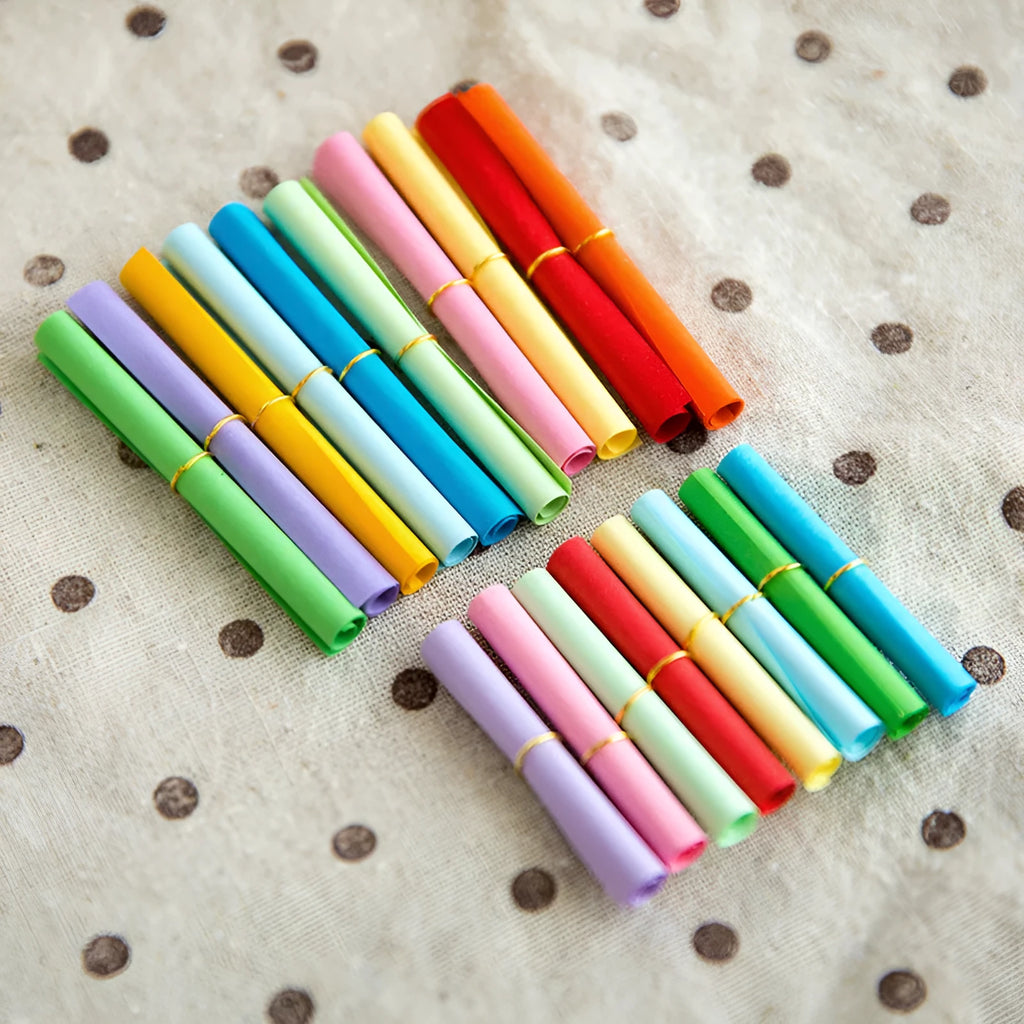Colourful miniature paper scrolls for drift bottle messages with central eyelet for string attachment