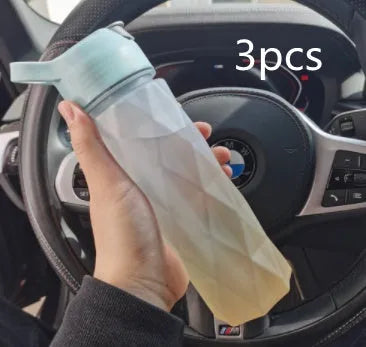 White 700ml plastic spray water bottle with handle strap and leakproof lid.
