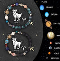 Twelve Zodiac beaded bracelets with natural stone beads and metal astrological charms on elastic cord.