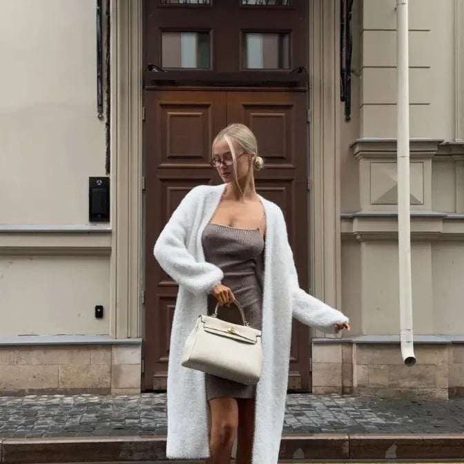 White oversized women's knit cardigan jacket with long line and regular sleeves.