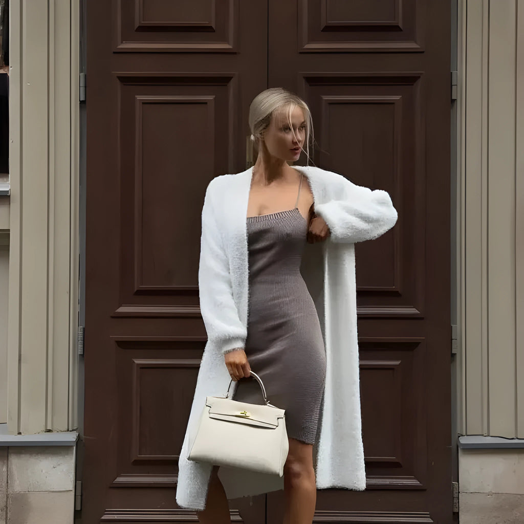 White oversized women's knit cardigan jacket with long line and regular sleeves.