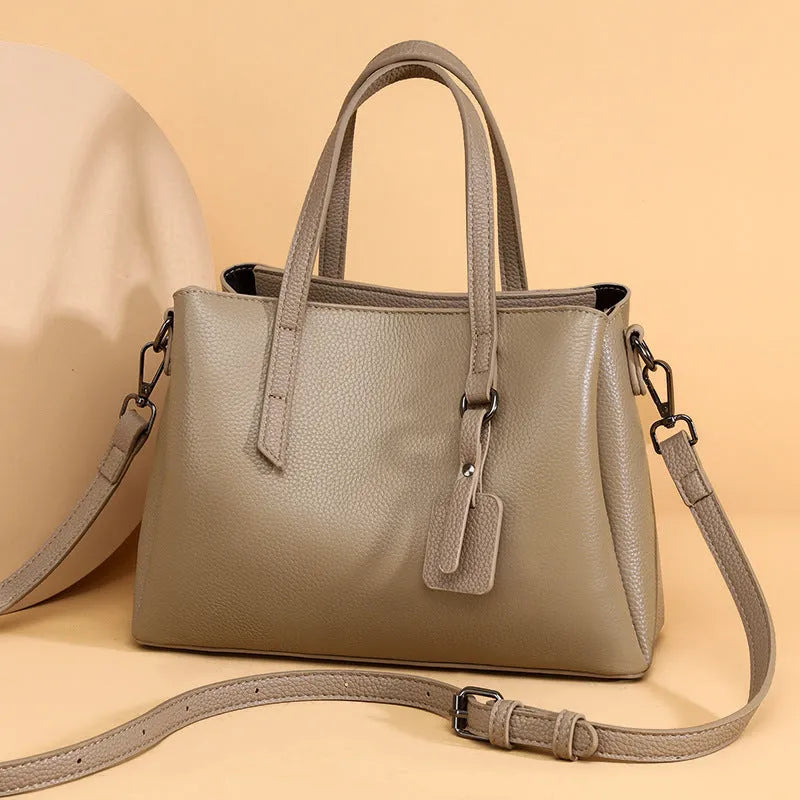 Women's cowhide leather large capacity handbag in horizontal square shape with single shoulder strap.