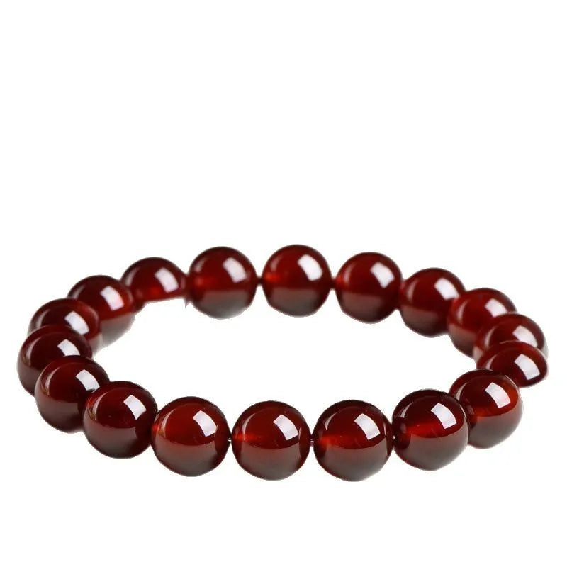 Natural orange red garnet ball bracelet with crystal beads and Ruyi design on a wrist.