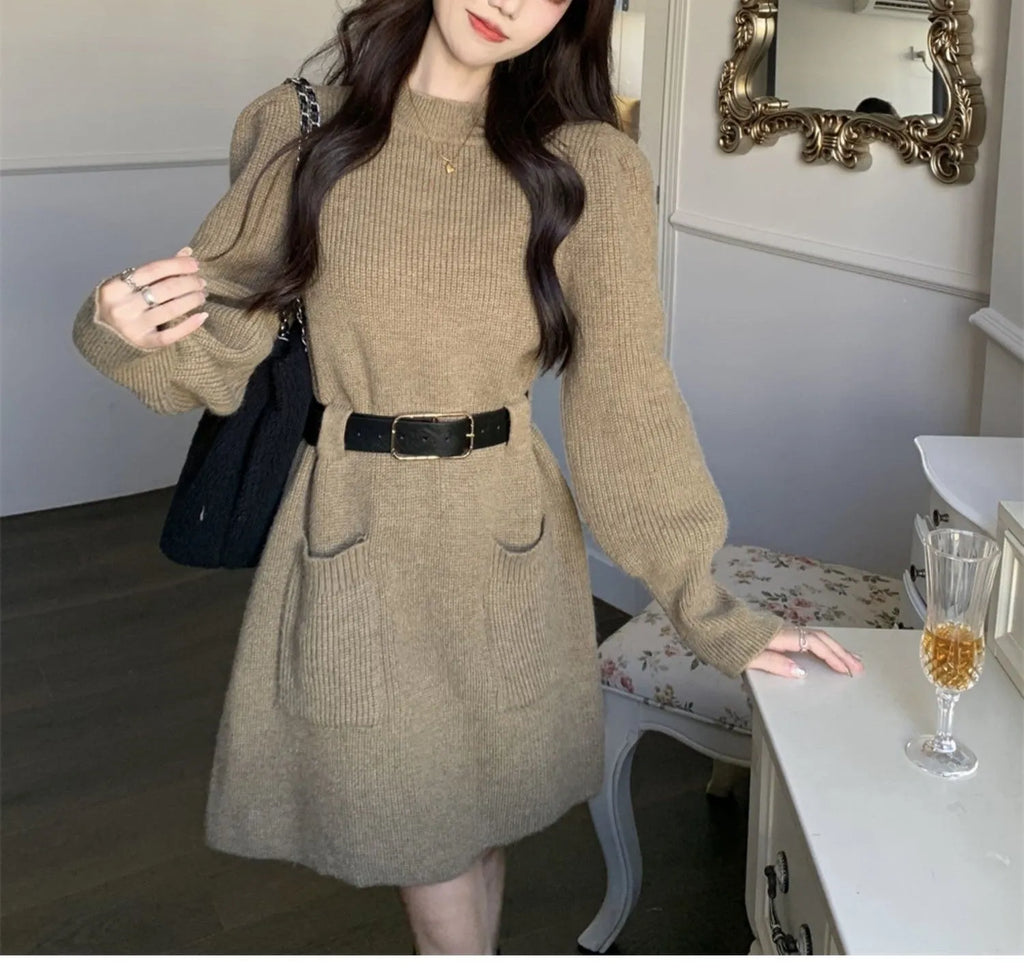 Women's beige long sleeve loose knit dress with a black belt on a hanger.