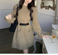 Women's beige long sleeve loose knit dress with a black belt on a hanger.