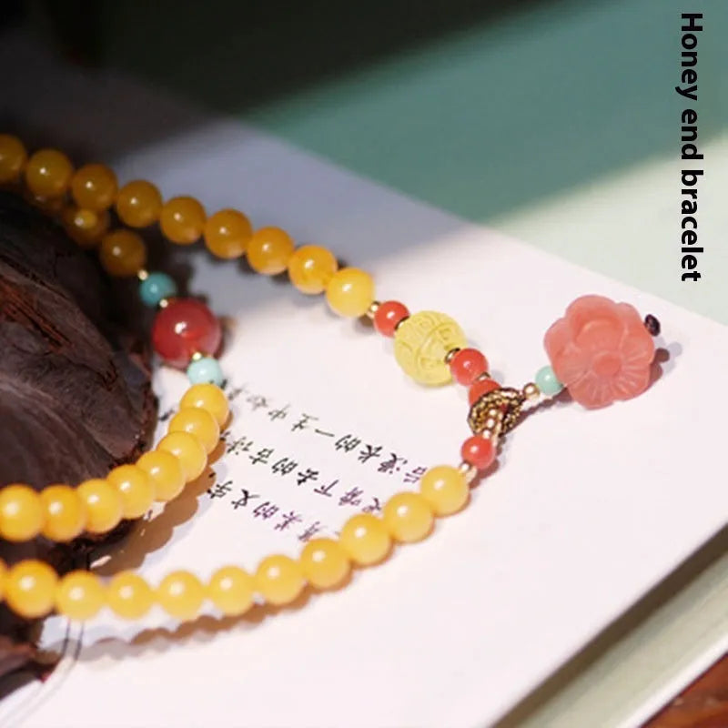 Close-up of a women's amber bracelet with animal modelling on round 5mm beads.