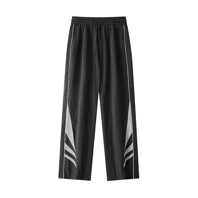 A man wearing black straight-leg loose-fit casual sports trousers for summer.