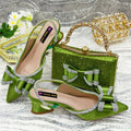 Women's black pointed toe sandals with square buckle and matching rhinestone bag on a mid-height wine glass heel.