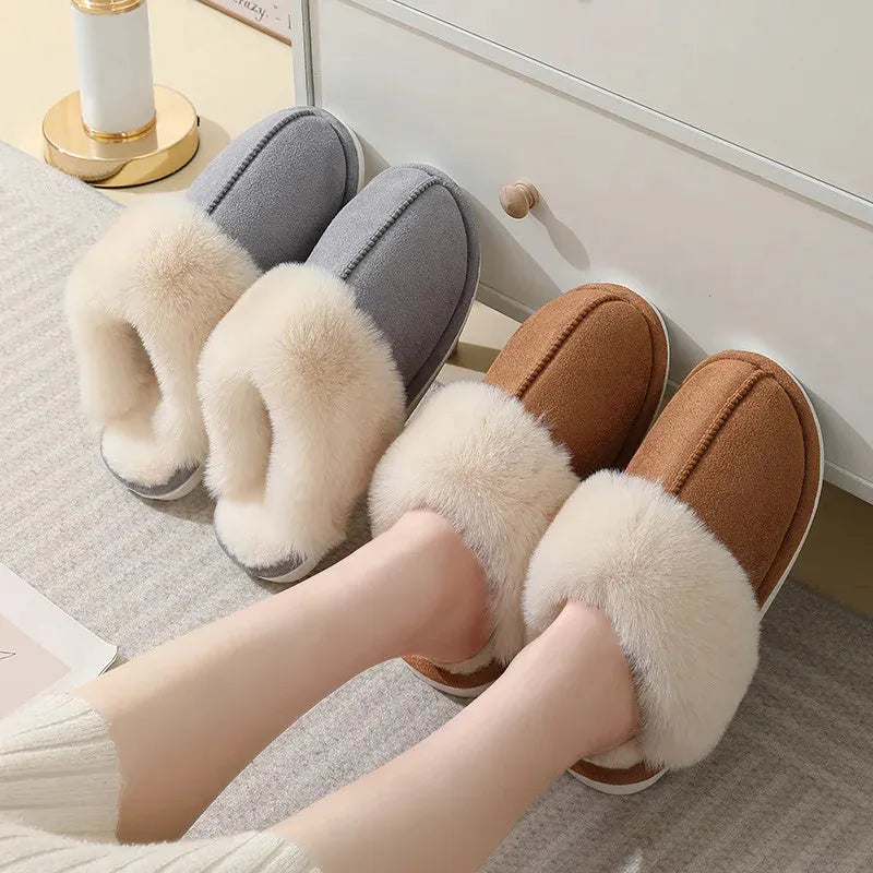 Women's brown plush indoor slippers with a round toe, flat heel, and stitching detail.