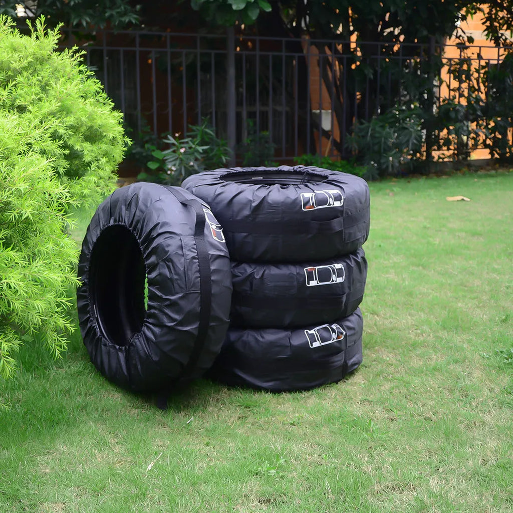 Set of four black Oxford cloth car tyre protective covers laid flat