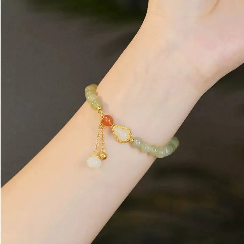 Natural jade bead bracelet with a gold-plated gourd charm and fu character.