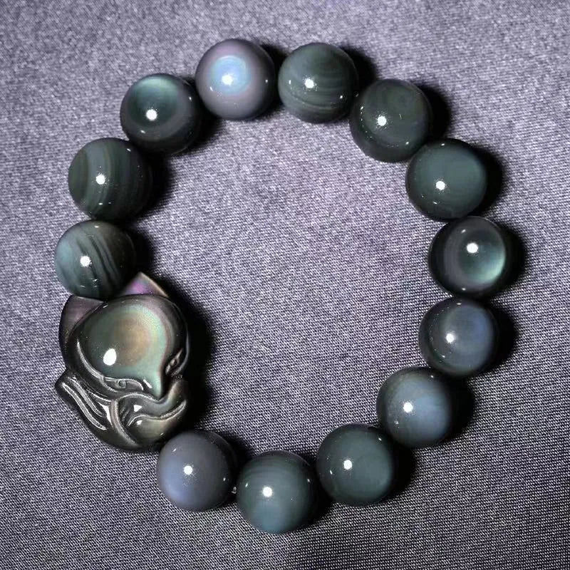 Obsidian fox carved bracelet in cartoon animal style showing detailed carving on black stone surface