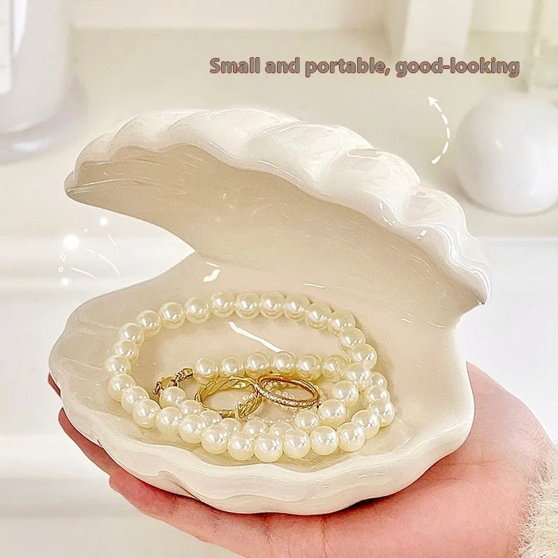 White porcelain decorative shell-shaped tray with a matching small night lamp on a wooden surface.