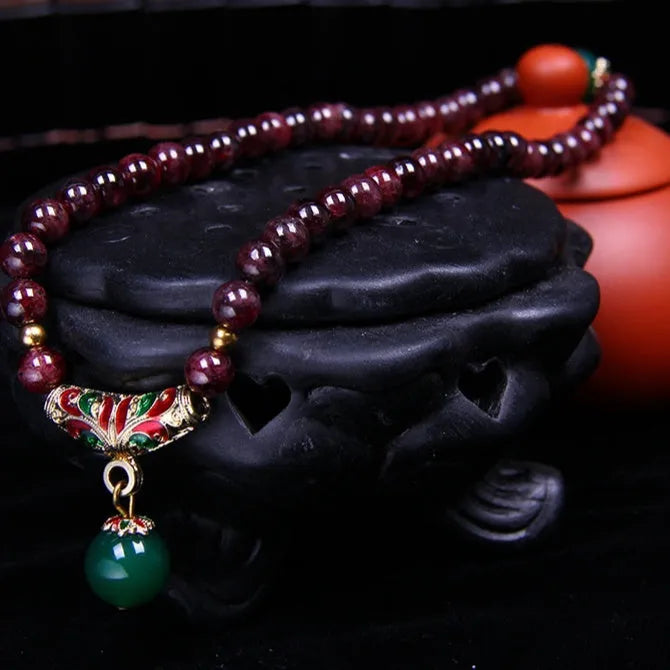 Natural garnet bracelet with 7mm beads and double-ring clasp for women, showing ordinary and upgraded quality options