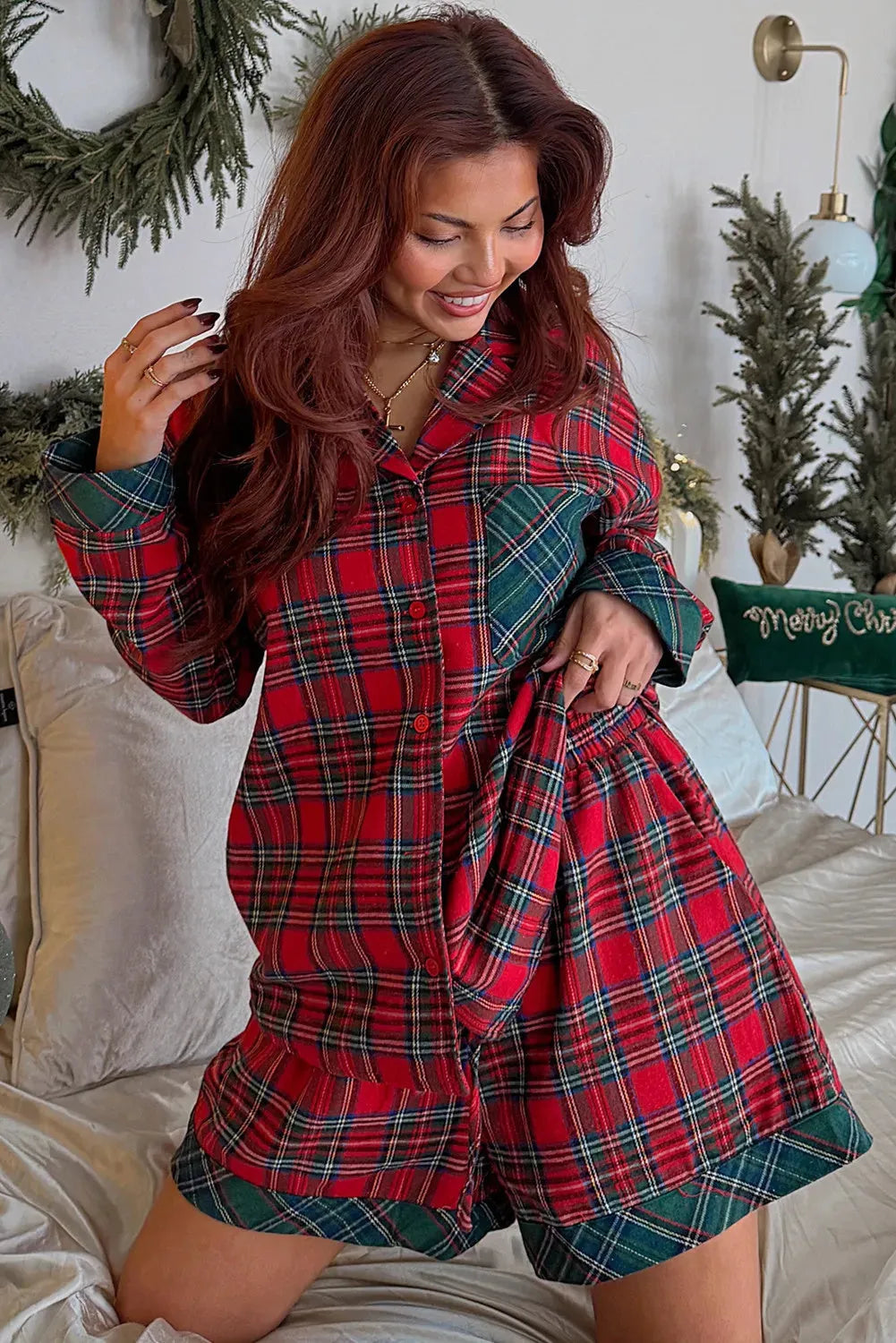 Red and black plaid adult pyjama set with long sleeve shirt and shorts on a hanger.