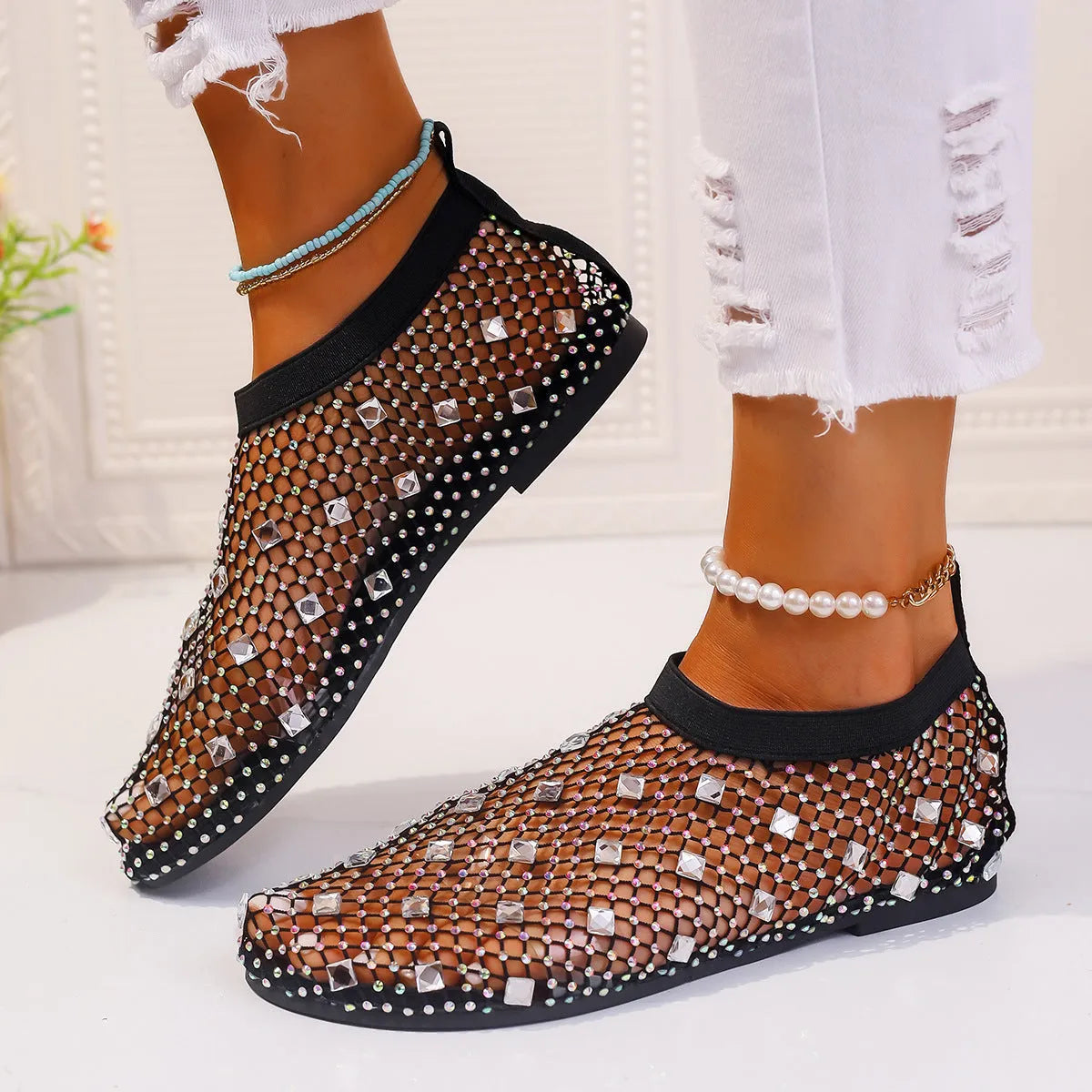 Women's flat mesh sandals with colourful rhinestone detail on a white background.