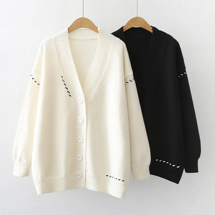 Women's loose black knitted cardigan coat with long sleeves on a hanger