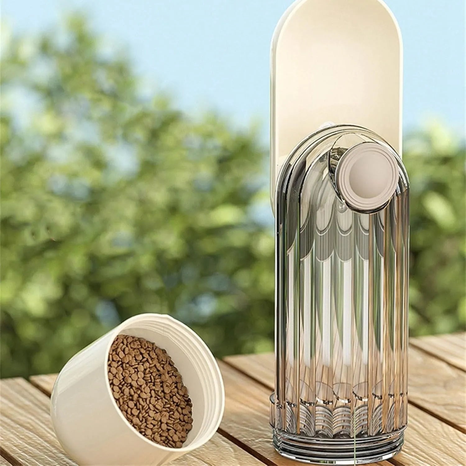 Beige and green foldable dog water bottle with food dispenser for outdoor use.