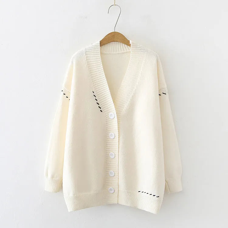 Women's loose black knitted cardigan coat with long sleeves on a hanger