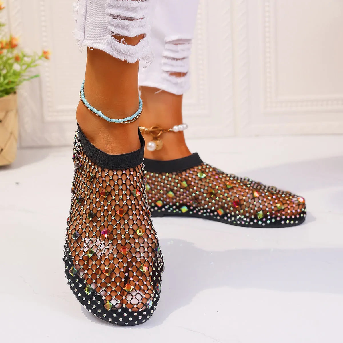 Women's flat mesh sandals with colourful rhinestone detail on a white background.