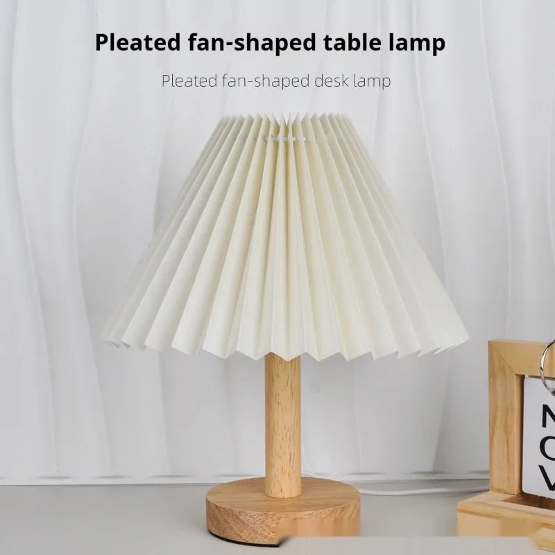 Vintage pleated umbrella-shaped USB bedside lamp with remote control on a wooden table.