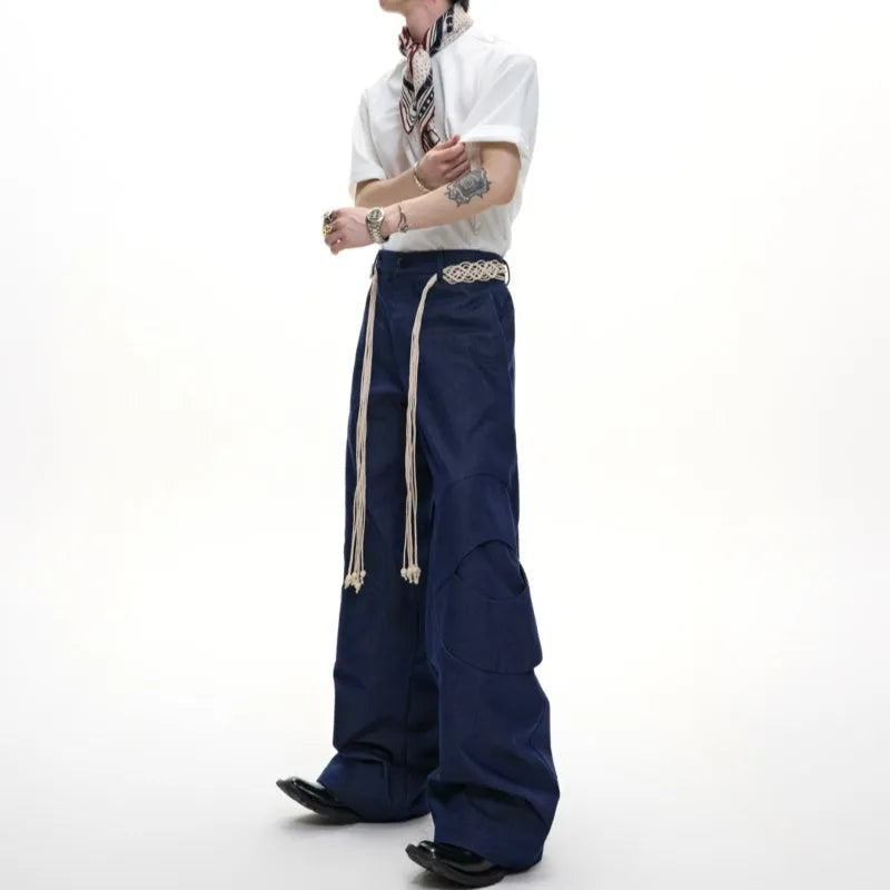 Men's dark blue straight-leg jeans with zipper decorations and tassel details on a loose cotton fit.