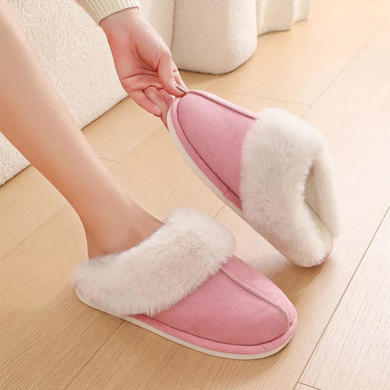 Women's brown plush indoor slippers with a round toe, flat heel, and stitching detail.