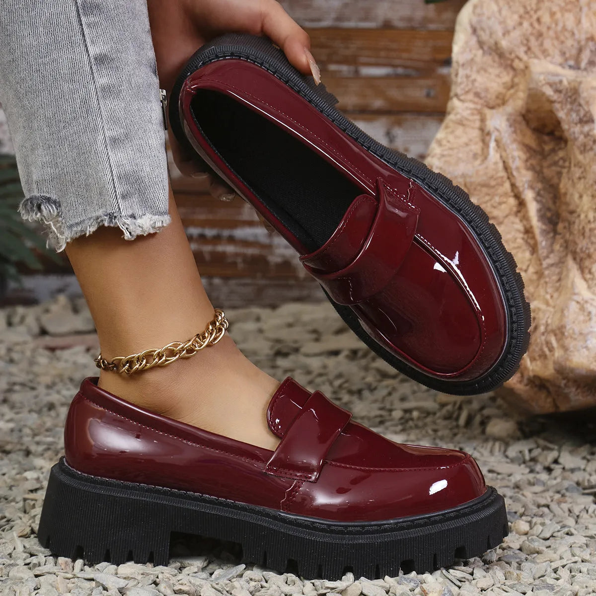 A pair of black plus size slip-on loafers with a chunky mid-heel and thick rubber sole on a plain background.