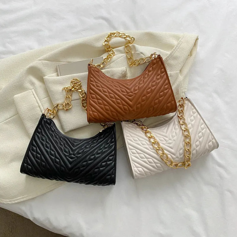 Brown vertical PU leather shoulder bag with a silver pleated chain strap and a soft handle.