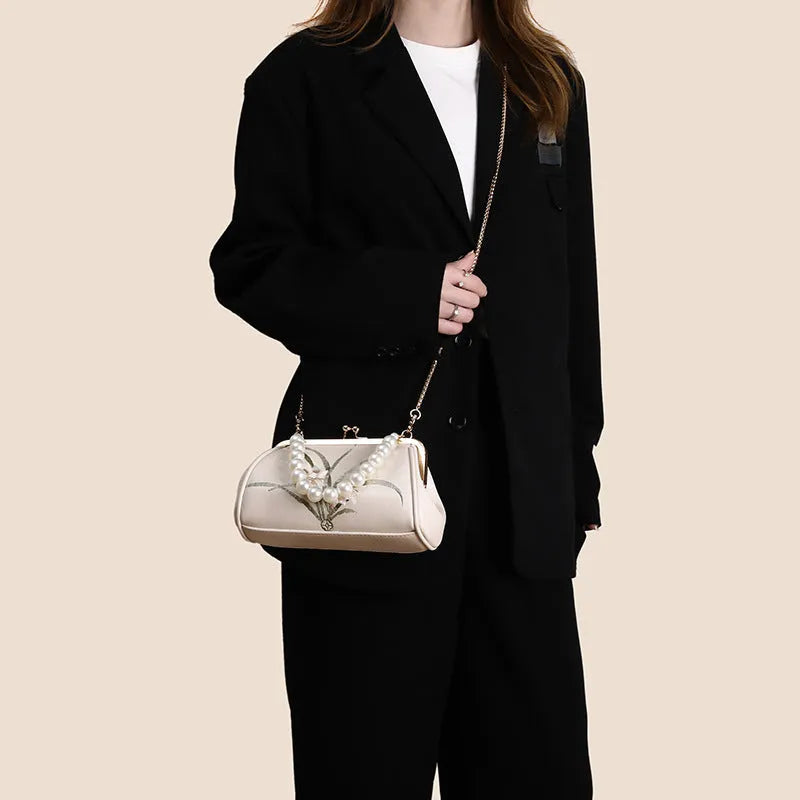 Beige women's embroidered shoulder bag with shell shape design made from soft PU leather