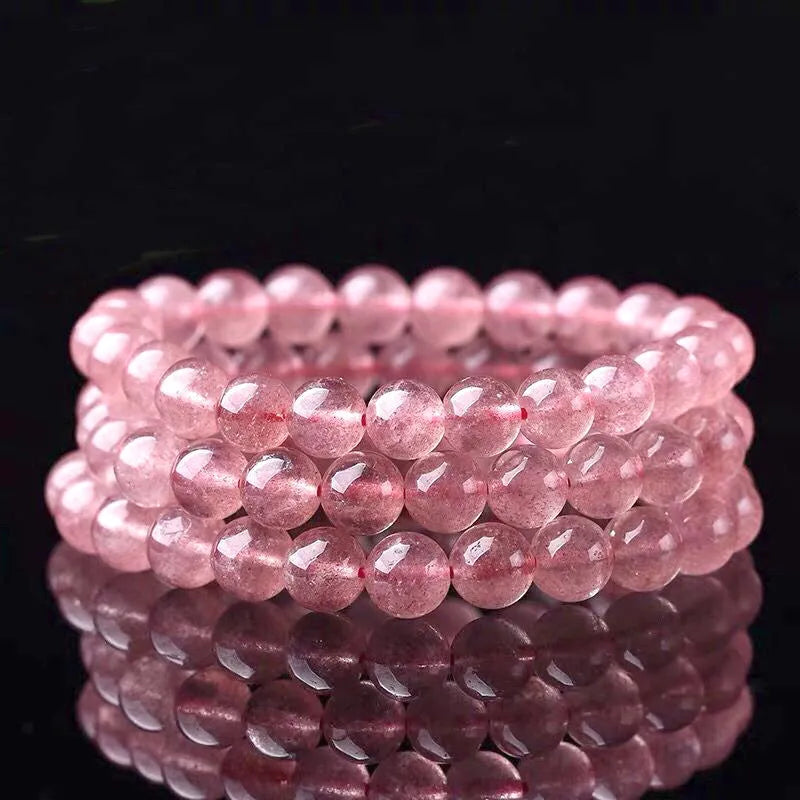 Polished strawberry quartz crystal bracelet for women, shown in three bead size options: 6mm, 8mm, and 10mm.