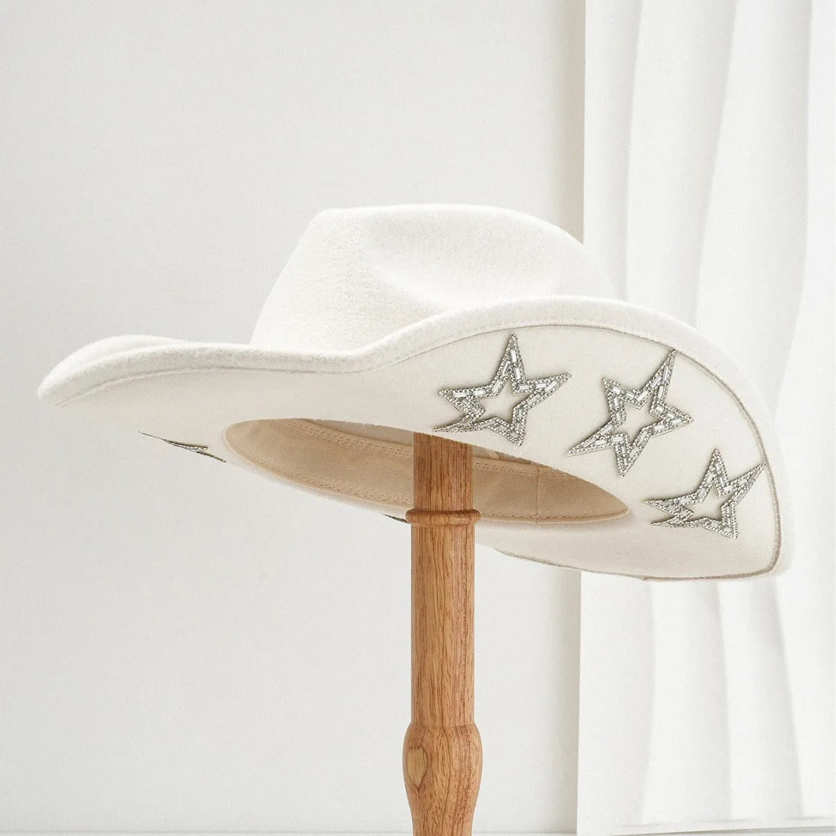 Beige western-style conical top hat with a hexagonal star decoration on the front.