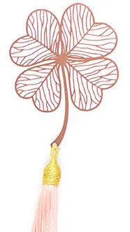 Detailed brass bookmark with hollow maple leaf pendant and rose gold tassel on a book page.