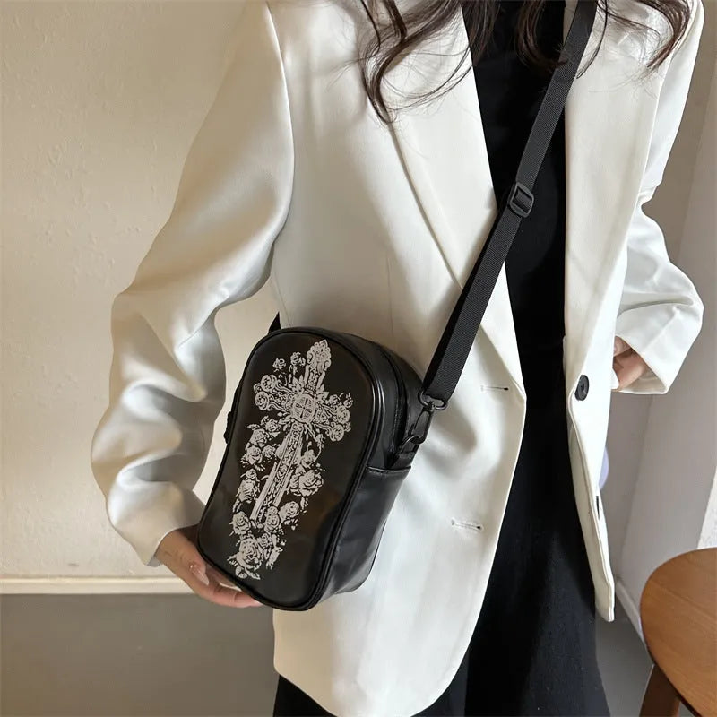 Black Halloween graffiti crossbody bag with cartoon pumpkin, ghost, and bat print, shown with adjustable strap.