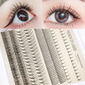 DIY false eyelash kit showing segmented single-cluster lashes, adhesive bottles, tweezers, and a brush on a pink and black background.