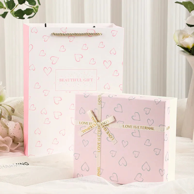 Cardboard gift box with bow in red, green, and pink, multiple sizes for gifts