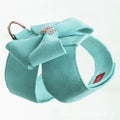 A pink dog harness with a white bow knot on an adjustable microfiber chest strap.