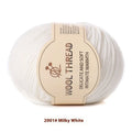 One roll of beige domestic wool hand-knitting yarn for size 10 needles next to knitting needles.